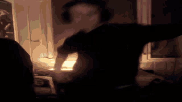 a man wearing headphones is dancing in a dark room .