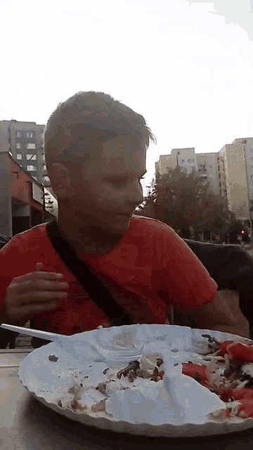 a young boy sitting at a table with a plate of food on it