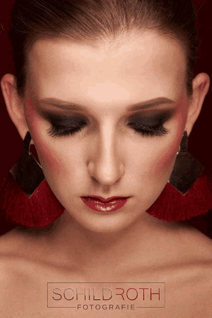 a close up of a woman 's face with the name schildroth on the bottom right