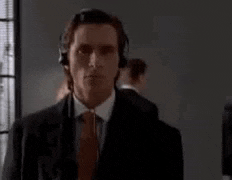 a man in a suit and tie is wearing headphones and standing in a room .