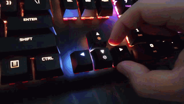 a person is typing on a keyboard with the enter and ctrl keys lit up