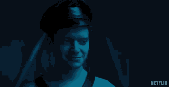 a man is smiling in a dark room with a netflix logo on the bottom right