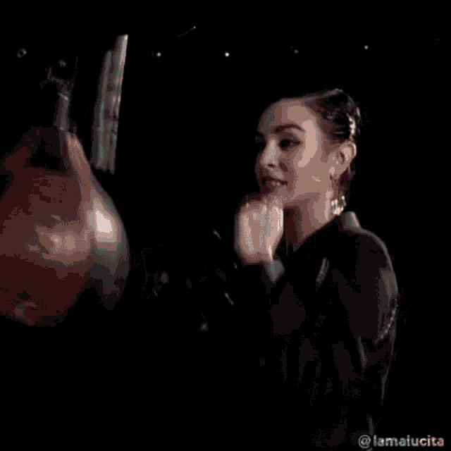 a woman is punching a punching bag in the dark .
