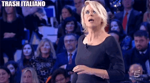 a woman in a black dress is standing in front of a crowd and the words trash italiano are above her