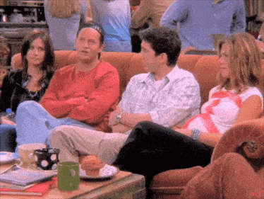 a group of people are sitting on a couch and one of them is wearing a hat that says ' ec '