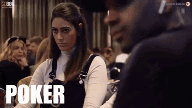 a woman sitting at a table with the word poker on her shirt
