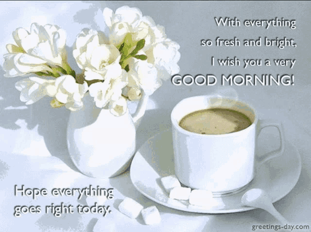 a cup of coffee sits on a saucer next to a vase of flowers and a good morning message