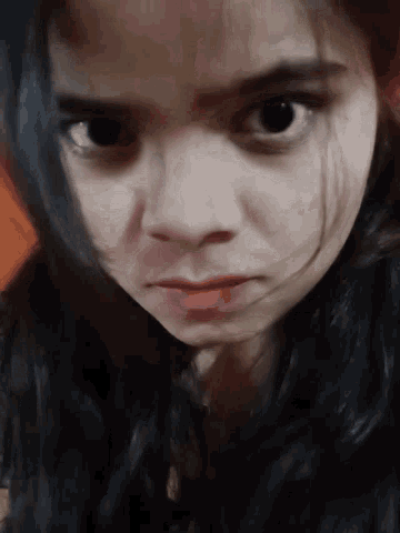 a close up of a woman 's face with a serious expression