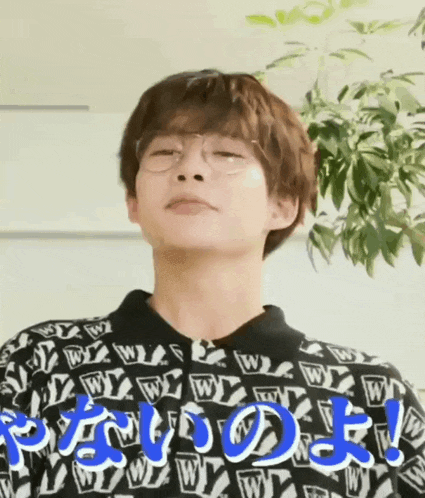 a man wearing glasses and a sweater with the letter w on it is making a funny face