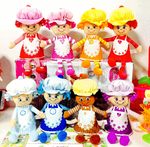 a group of stuffed strawberry shortcake dolls sitting on a table