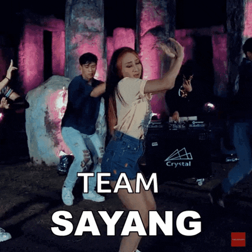 a group of people are dancing in front of a crystal logo