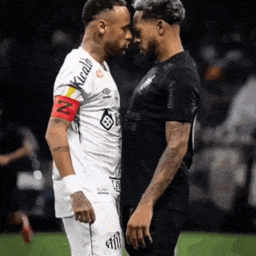 two soccer players face to face with one wearing a shirt that says ' kicads ' on it