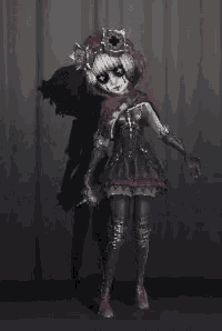 a woman in a clown costume is standing in front of a curtain in a dark room .