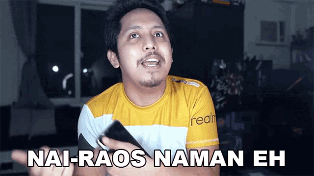 a man in a yellow shirt with the words nai-raos naman eh on the bottom