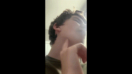 a young man is touching his face with his hand .