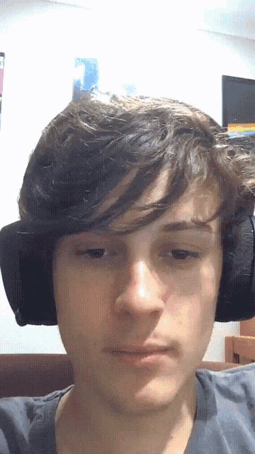 a man wearing headphones looks at the camera