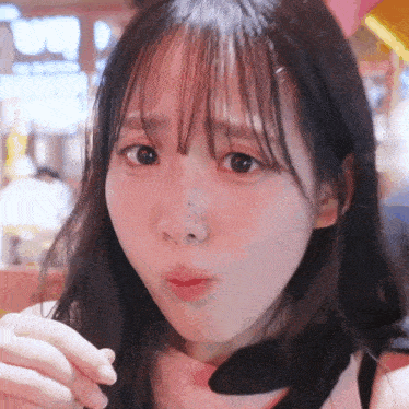 a close up of a girl 's face with a pink background
