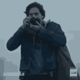 a man is taking a picture with a camera in his hand .