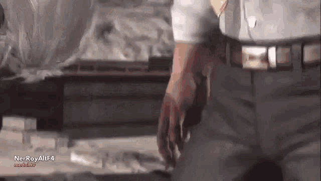 a man in a white shirt and black pants is standing next to a table .