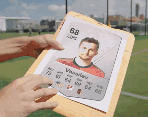 someone is holding a clipboard with a picture of a soccer player named vassilev