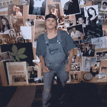 a woman in overalls stands in front of a wall full of pictures including one that says ' i love you '