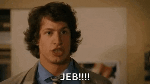 a man in a suit and tie is making a funny face and says jeb !!! .