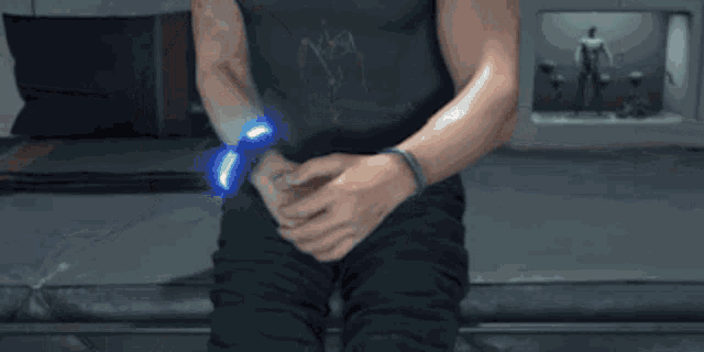 a man wearing a black shirt and black pants holds a blue spinner in his hand