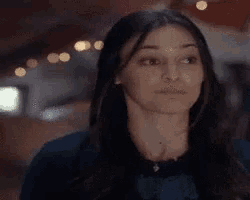 a woman with long hair is making a funny face while looking at the camera .