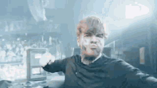 a man with a beard is making a funny face while taking a selfie on a stage .