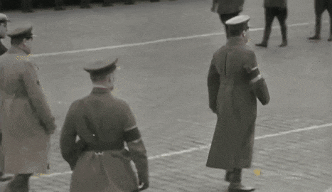 a man in a trench coat is holding a red flag that says cccp on it .