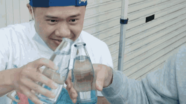 a man is pouring water into a glass bottle
