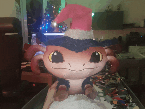 a stuffed animal wearing a santa hat is sitting on a table