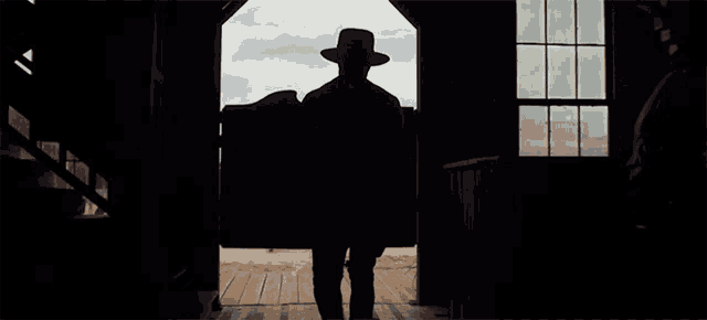 a man in a hat stands in front of another man