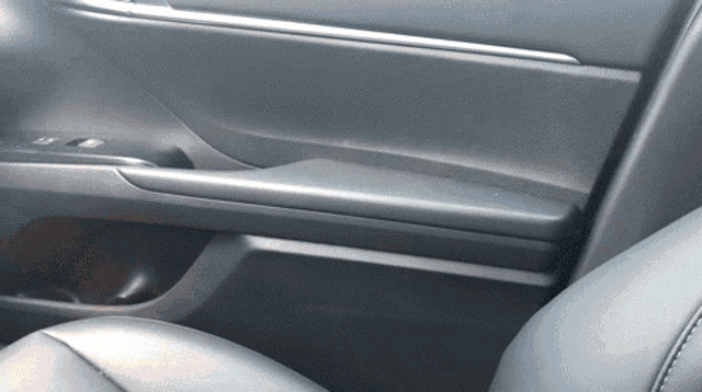 a close up of a car door with a black leather seat