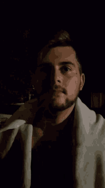 a man with a beard smoking a cigarette in the dark