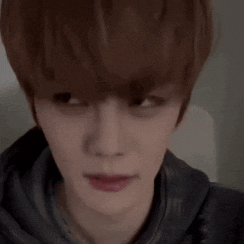 a close up of a person 's face with a hoodie on