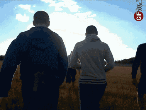 a group of men are walking in a field with the word me on the bottom