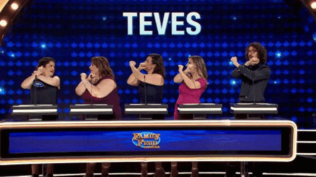 a group of people standing in front of a screen that says teves on it