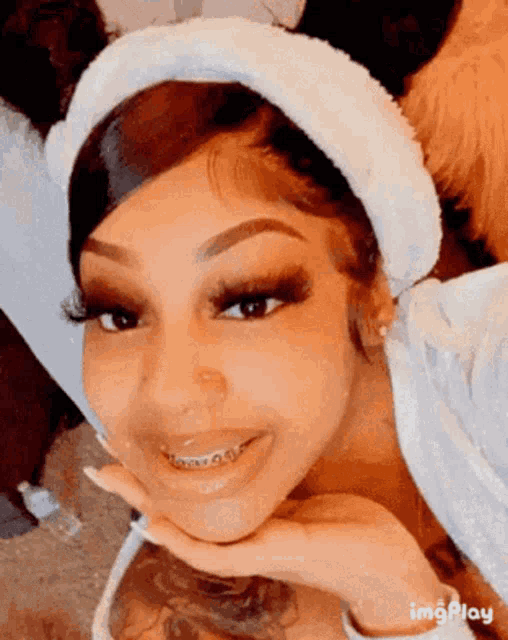 a woman with braces on her teeth is wearing a white headband .