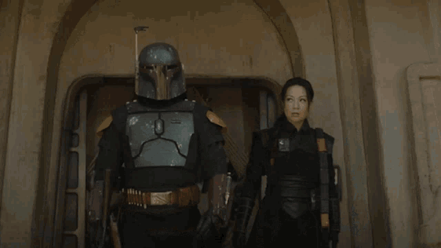 a man in a helmet is standing next to a woman in a black outfit