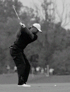 a man swings a golf club on a golf course