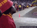 a man wearing a red hat that says boston is watching a football game