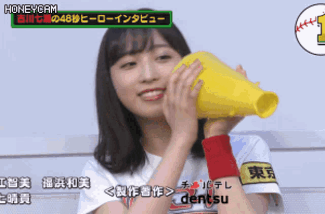 a girl is holding a yellow megaphone in front of her face and the words honeycam are on the bottom