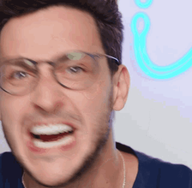 a man wearing glasses is making a funny face with his mouth open