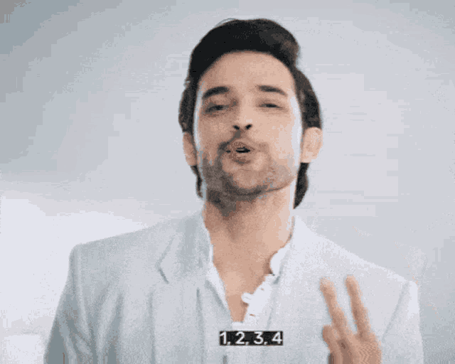 a man wearing a white shirt and a blue jacket has the numbers 1,2,3,4 on his chest