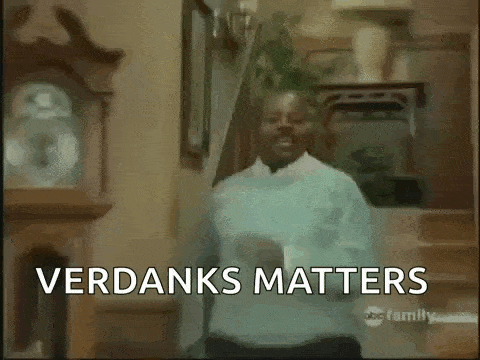 a man is dancing in a living room with the words verdansks matters written on the screen behind him .