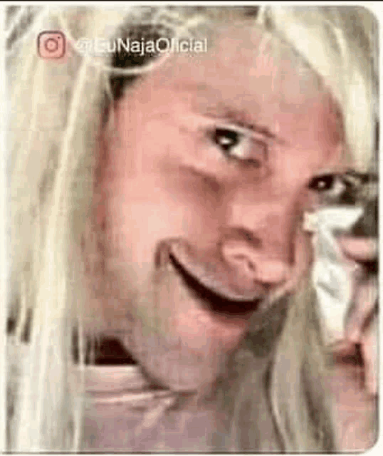 a close up of a woman 's face with a beard and blonde hair making a funny face .