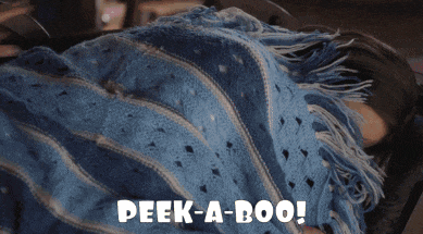 a woman is laying under a blue blanket with the words peek-a-boo