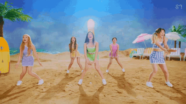 a group of girls are dancing on a beach with the letters s on the bottom left