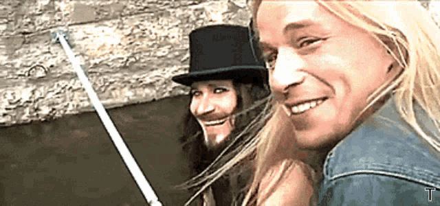 a man with long hair and a beard wearing a top hat
